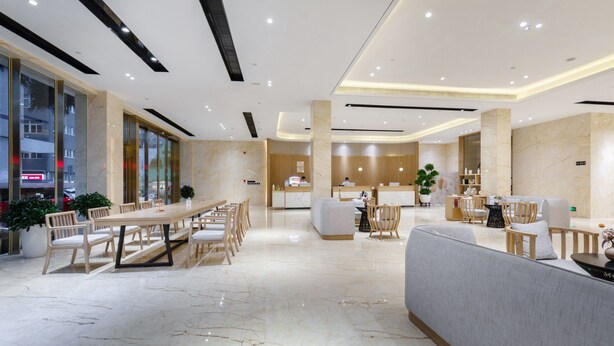 A spacious lobby with a marble floor, wooden furniture, and a reception desk. - Apex Hotel  (Shenzhen)
