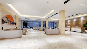 A spacious lobby with marble flooring, a reception desk, seating areas, and large windows. - Apex Hotel  (Shenzhen)