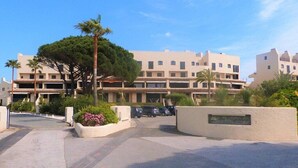 Un hôtel à plusieurs étages doté d’une cour intérieure, de palmiers et d’un espace de stationnement.