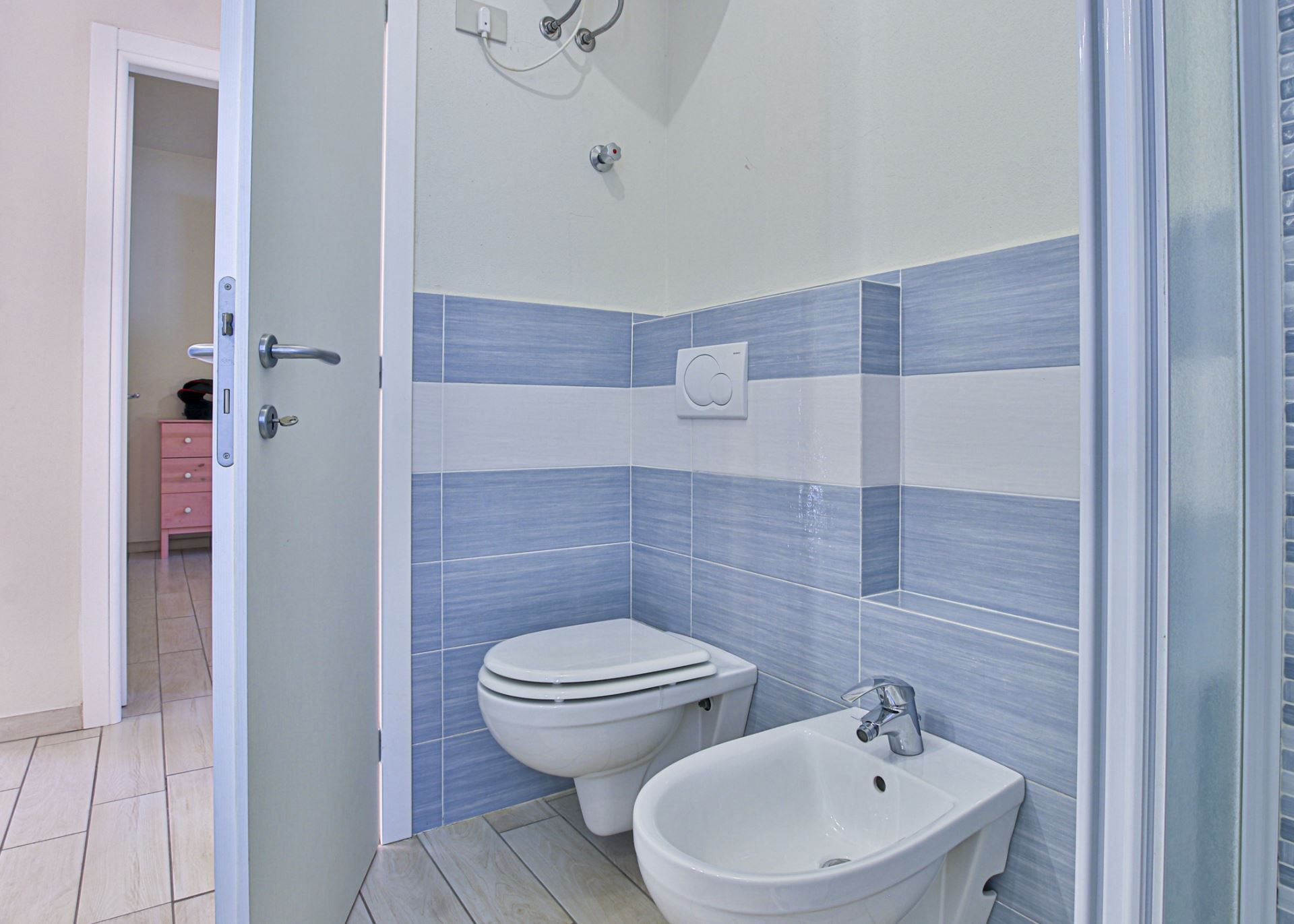 Un bagno con un WC, un bidet e un lavandino.