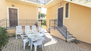 A patio with a table and chairs, a staircase, and a door. - Vania, in Marina di Campo, is located in a residential area, convenient to the beach and services, w (Campo nell'Elba)
