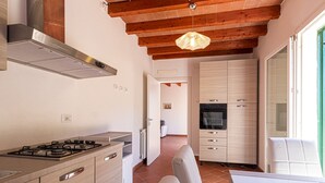 Eine moderne Küche mit Gasherd, Holzschränken und Backofen.