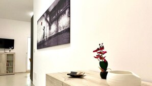 A modern interior with a wooden counter, a flat-screen TV, and a framed artwork on the wall. - Monopoly Sky House (Monopoli)