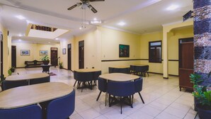 A hotel lobby with multiple seating areas, a ceiling fan, and artwork on the walls. - PIA Hotel Medan (Medan)