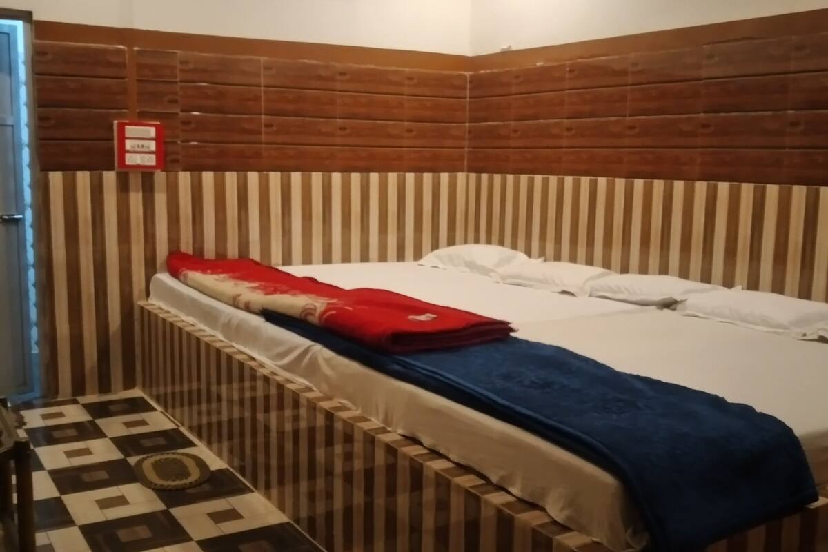 A room with a bed, striped headboard, and a patterned floor.