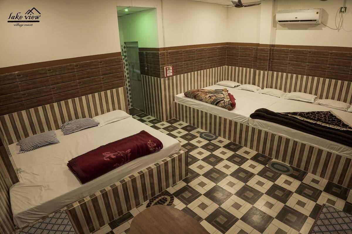 A room with two beds, striped walls, and a patterned floor.
