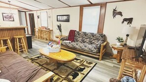 A cozy living room with a sofa, a coffee table, and a ceiling fan.