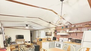A compact living space with a dining area, kitchen, and a television.