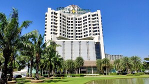 Um hotel grande e de vários andares, com uma placa chamativa no topo.