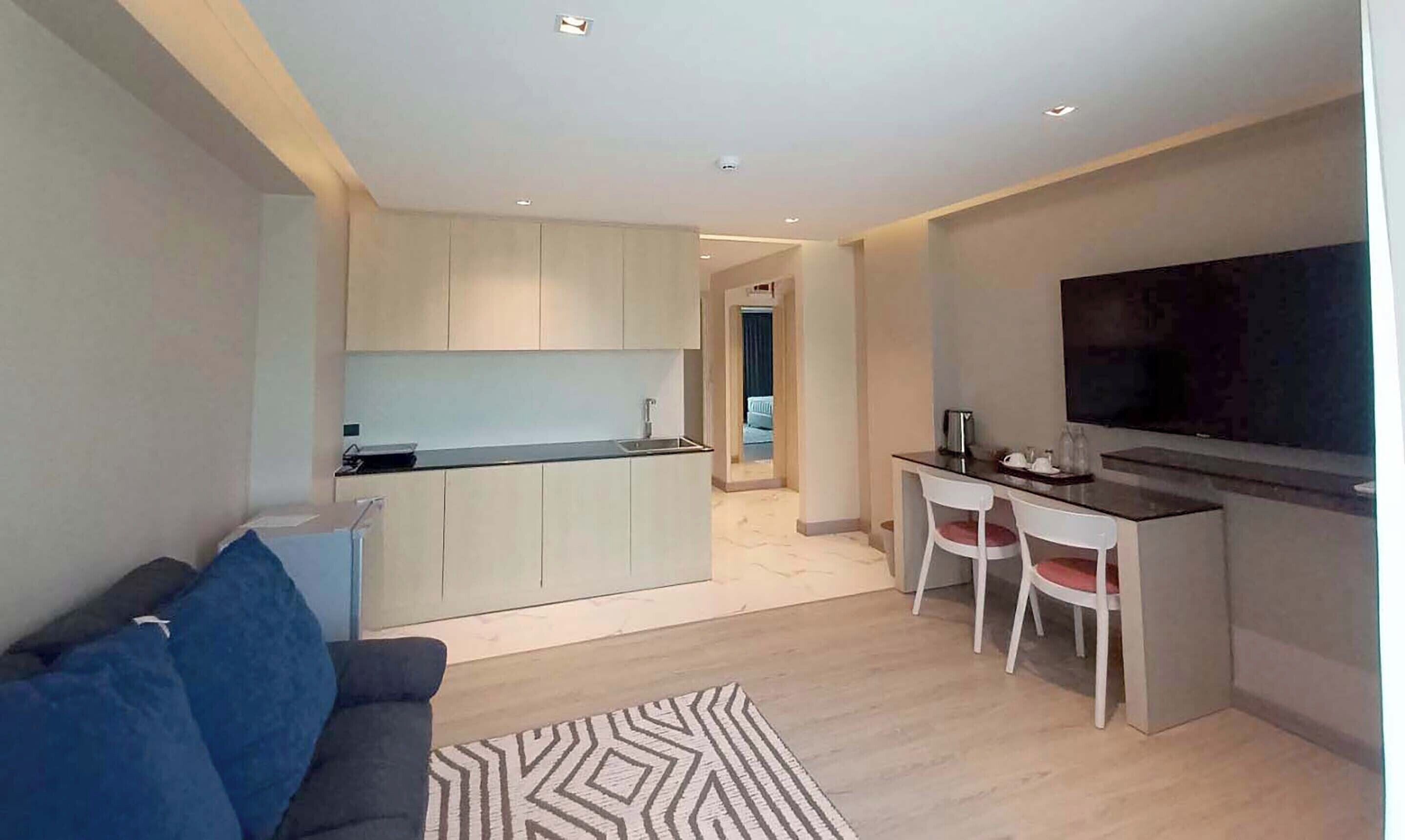 A modern apartment with a kitchen, dining area, and living room.