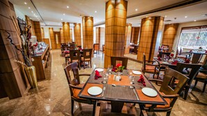Un restaurant doté de nombreuses tables, chacune étant dressée avec des assiettes, des couverts et des serviettes.