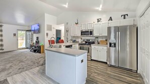 A modern kitchen with white cabinetry, stainless steel appliances, and a central island. - Richmond Home with Pool, 5 Mi to Downtown! (Richmond)