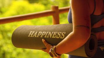 A person holding a yoga mat with the word 'HAPPINESS' on it.