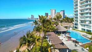 A resort with a pool, beach, and city skyline. - Camino al Mar, Apartment on the Beach with Fabulous Amenities Zona Dorada Pure Luxury (Mazatlán)