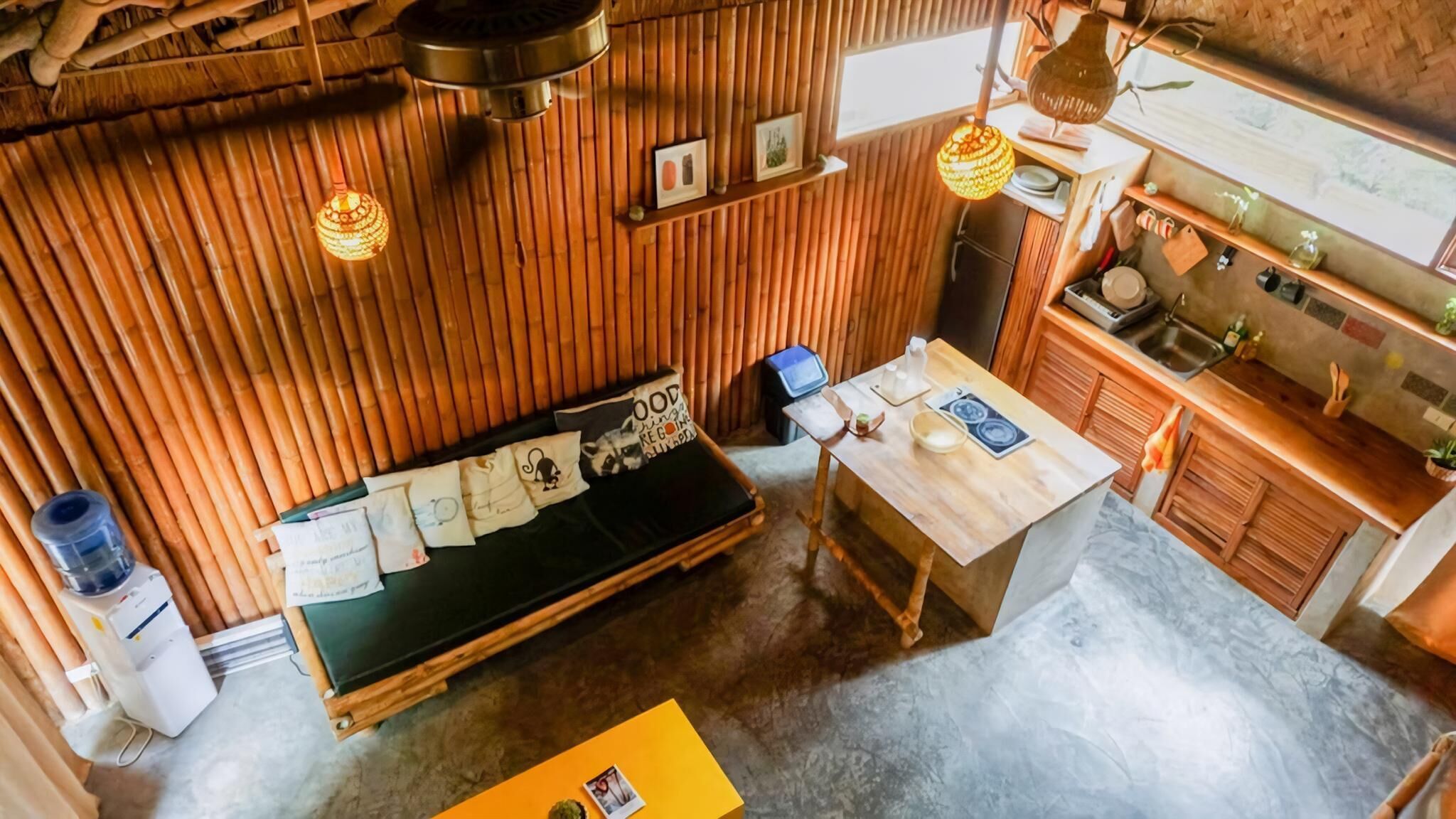 A compact kitchen with wooden walls, a dining table, and a bench.