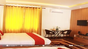 A hotel room with a large bed, a desk with two chairs, a television, and an air conditioning unit. - MeroStay 029 Royal Villa Resort (Tohka)
