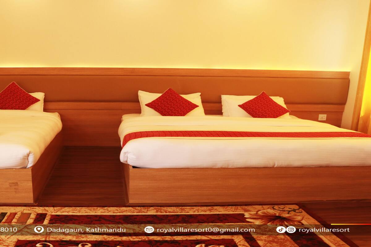 Two twin beds with wooden headboards, white bedding, and red decorative pillows.