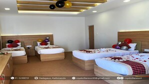 A hotel room with two beds, a wooden headboard, and a desk with a telephone and a water bottle. - MeroStay 029 Royal Villa Resort (Tohka)