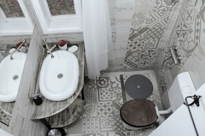 Une salle de bain avec deux lavabos, des toilettes et des carreaux décorés.