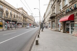 Une rue bordée de bâtiments des deux côtés, dont un cinéma et un magasin avec un auvent rouge.