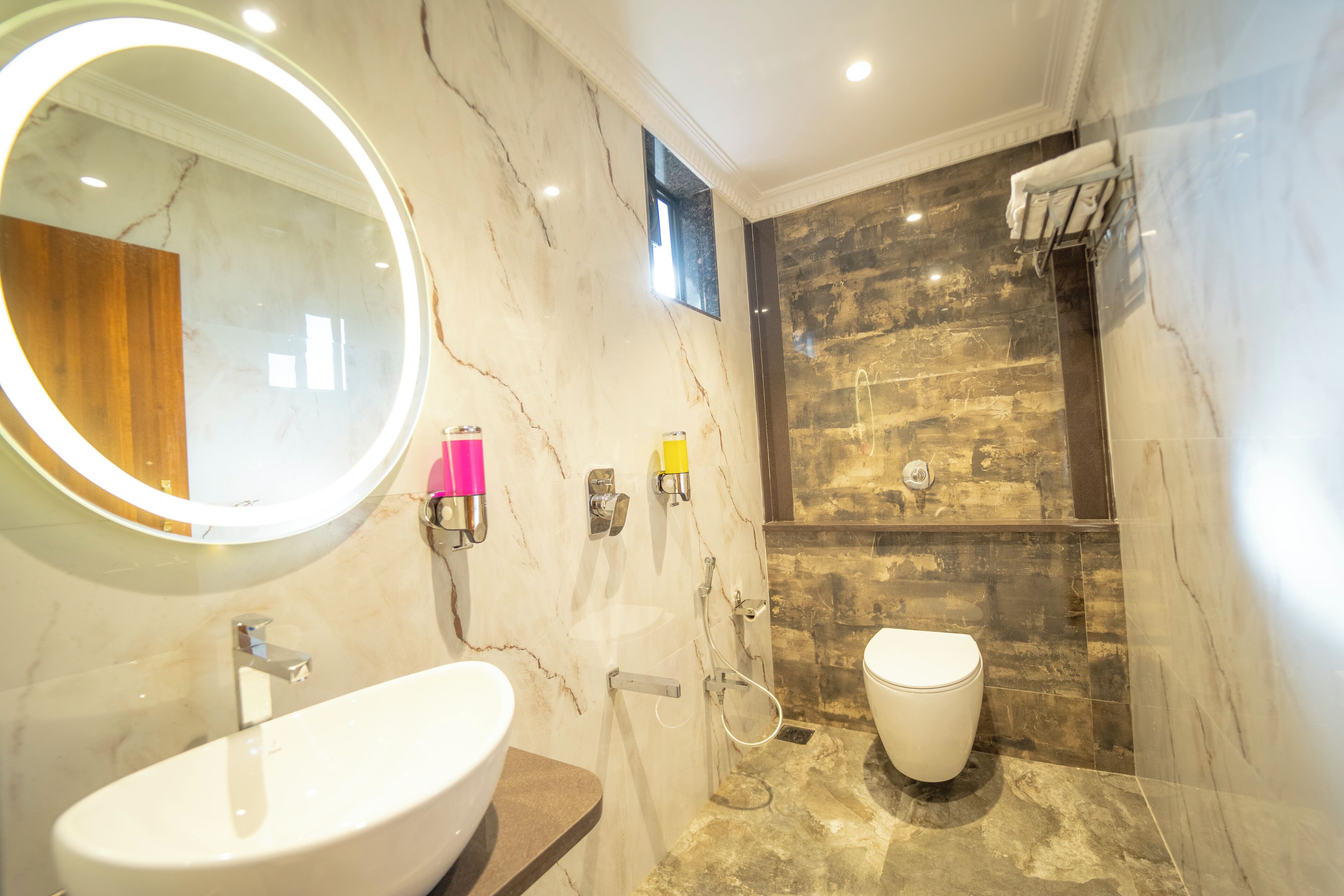 A bathroom with a marble sink, a toilet, and a shower area.