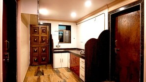 A narrow kitchen with wooden cabinets, a sink, and a window.
