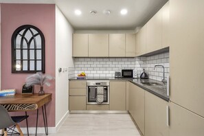 Enjoy cooking in this well-equipped kitchen with oven and microwave, adjacent to a cozy dining area.
