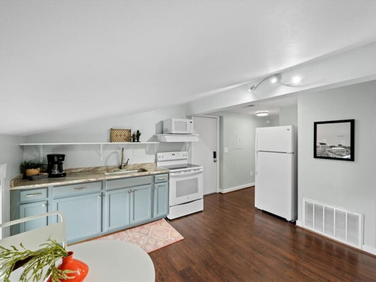 Una cocina moderna con armarios azul claro, una estufa blanca y un refrigerador blanco.