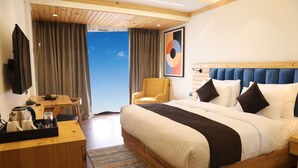 Une chambre d’hôtel avec un lit, un bureau, une chaise et un téléviseur.