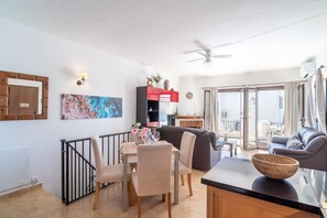 Ein modernes Wohnzimmer mit Essbereich, einer Couch, einem Couchtisch und einem Balkon mit Blick.