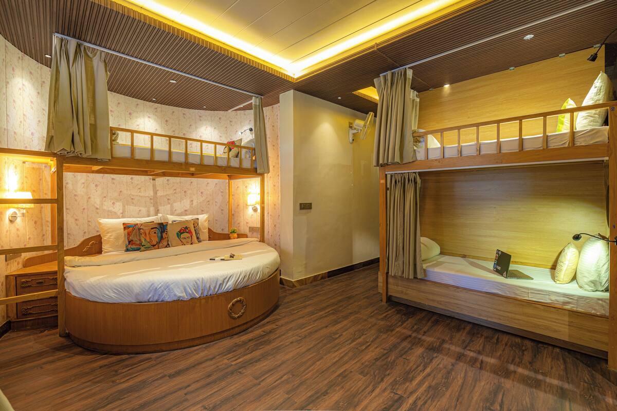 Ein Zimmer mit Etagenbett, Rundbett und Schreibtisch.