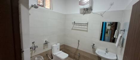 A bathroom with a toilet, bidet, sink, and a mirror.