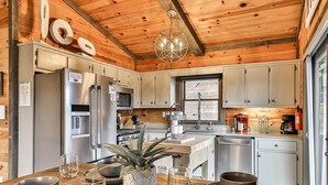 A wooden cabin interior with a kitchen, dining table, and a chandelier. - Cherry Log Sky Bear | Cherry Log, GA (Blue Ridge)