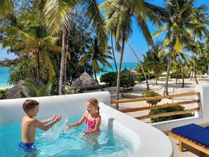 Una piscina al aire libre, sombrillas, sillones reclinables de piscina