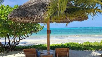 On the beach, white sand, sun loungers, beach umbrellas