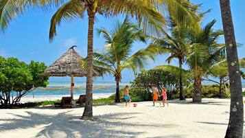 On the beach, white sand, sun loungers, beach umbrellas