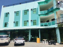 Um edifício de vários andares com fachada plana, janelas grandes e uma varanda no andar superior.