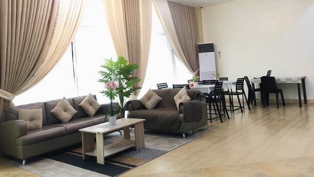 Ein modernes Wohnzimmer mit einer Couch, einem Couchtisch und einem Essbereich mit Stühlen und einem Tisch.