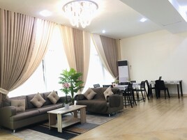 Uma sala de estar moderna com sofá, mesa de centro e área de jantar com cadeiras e mesa.