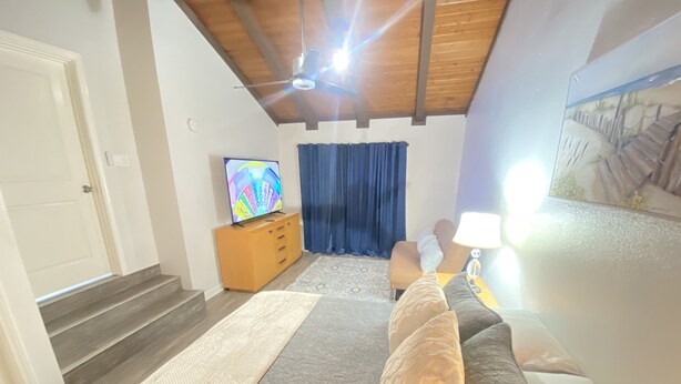 A bedroom with a bed, a TV, a wooden dresser, a lamp, and a painting on the wall. - BonVoyage-Sleep&Sail-OvernightLayovers-Sleeps 8 Near Airport-Cruise Ports (Long Beach)