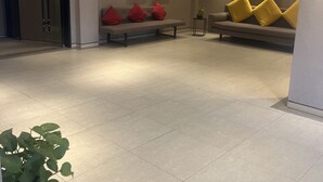 A modern lobby with a seating area, a potted plant, and a fire safety system. - Home Inns Collection Hotel (Shanghai)