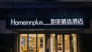 A hotel entrance with a sign reading "Homeinnplus" and Chinese characters. - Home Inns Collection Hotel (Shanghai)