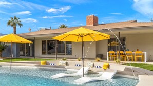 A swimming pool with two yellow umbrellas, lounge chairs, and a patio area with outdoor furniture. - The Long Ranch - Sprawling 1 acre Horse Park Hideaway (Thermal)