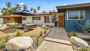A modern house with a patio, outdoor furniture, and a large umbrella. - The Long Ranch - Sprawling 1 acre Horse Park Hideaway (Thermal)