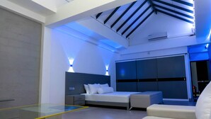 Un dormitorio moderno con cama, mesitas de noche, un separador de vidrio y un techo con tragaluces.