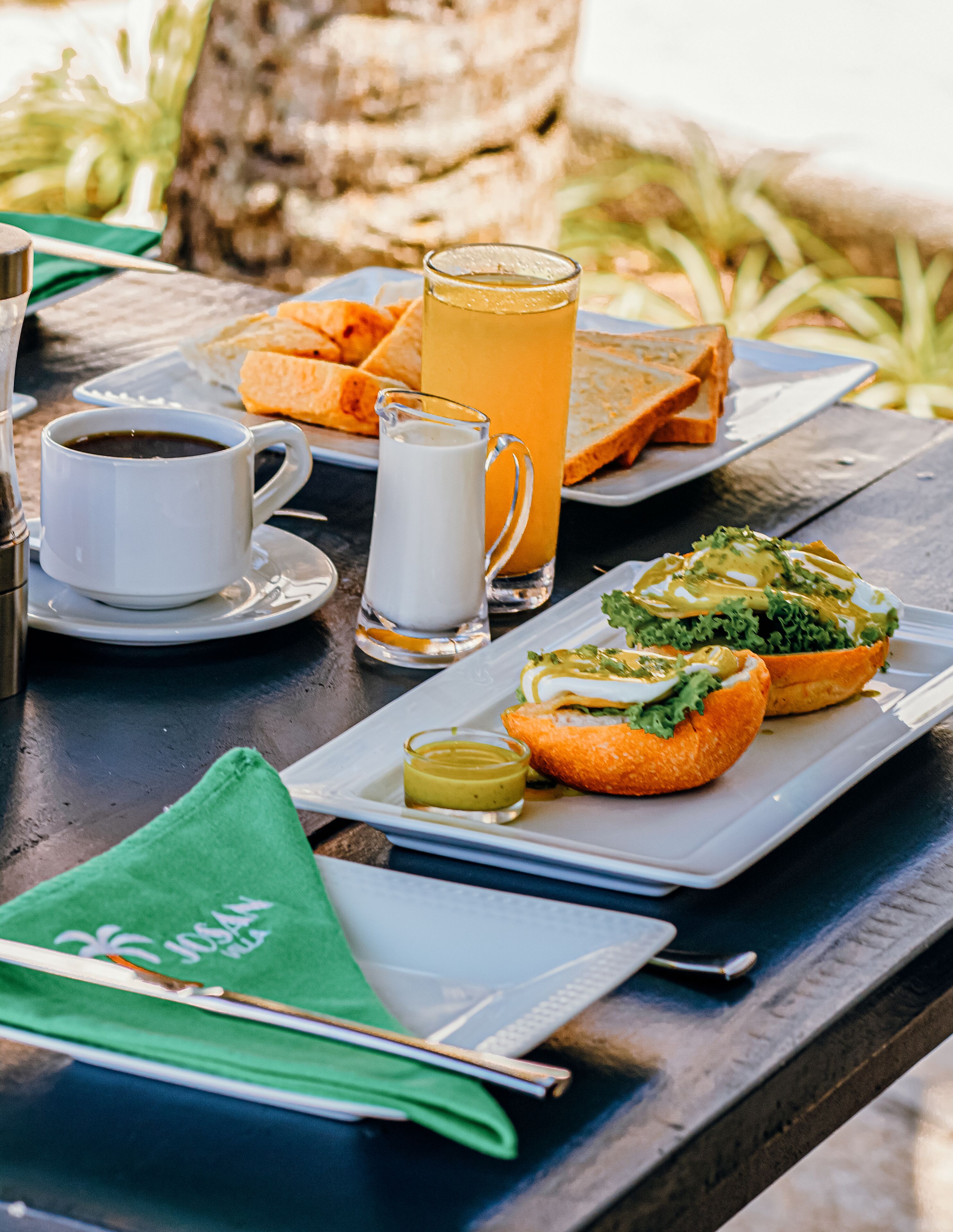 A table with a meal consisting of bread, a drink, and a cup of coffee.