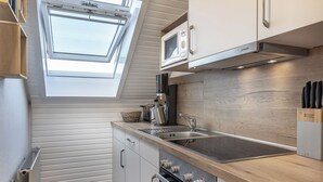 Eine moderne Küche mit Oberlicht, integriertem Mikrowellenherd und Edelstahlgeräten.