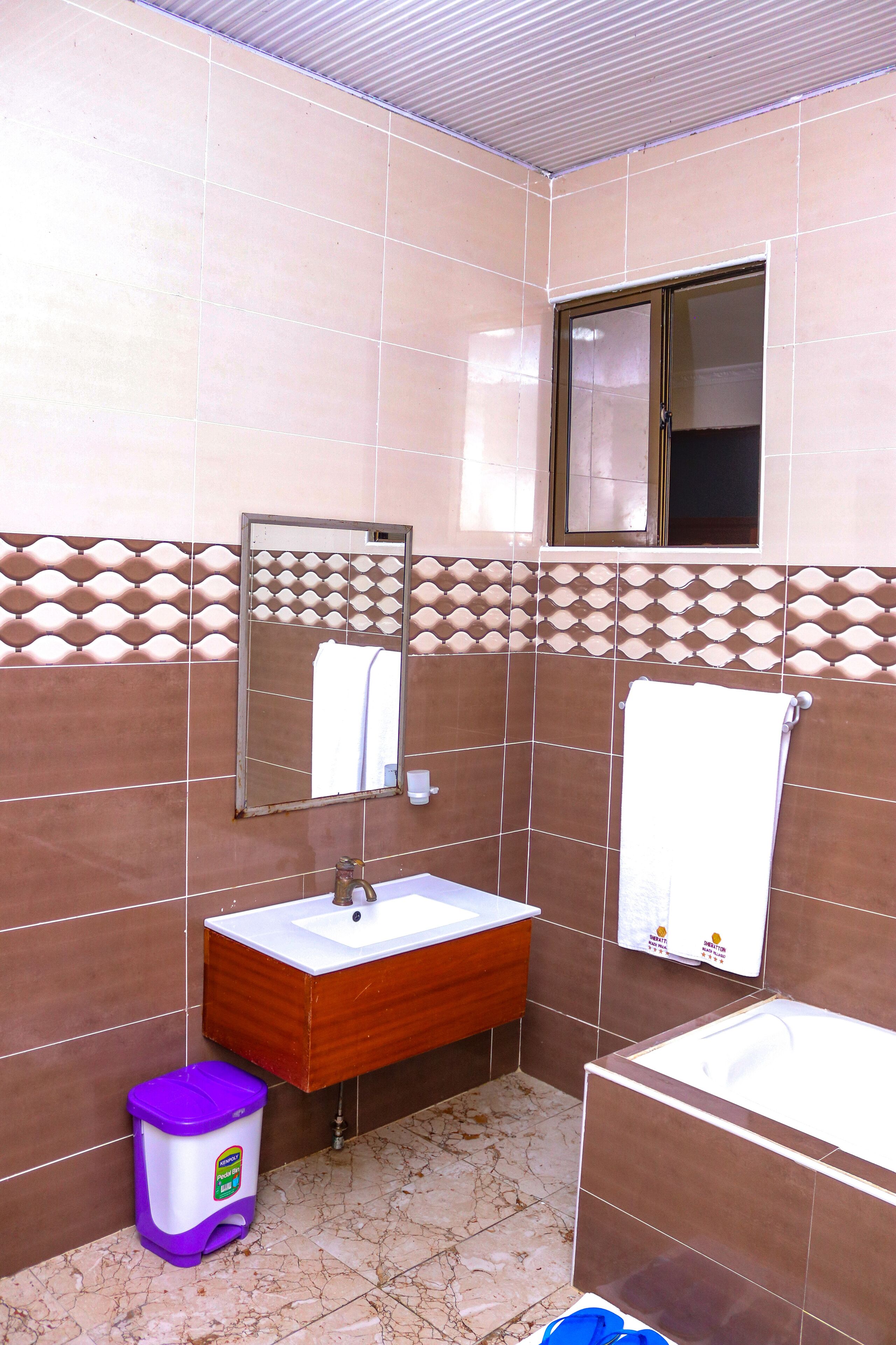 Un baño con lavamanos, espejo y bañera.