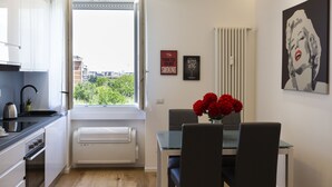Una cocina moderna con ventana, una zona de comedor con mesa y sillas, y un radiador.