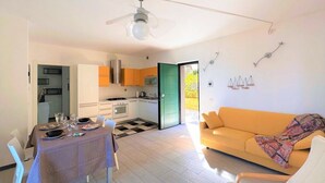 Un appartement moderne comprenant un coin repas, une cuisine et un salon.